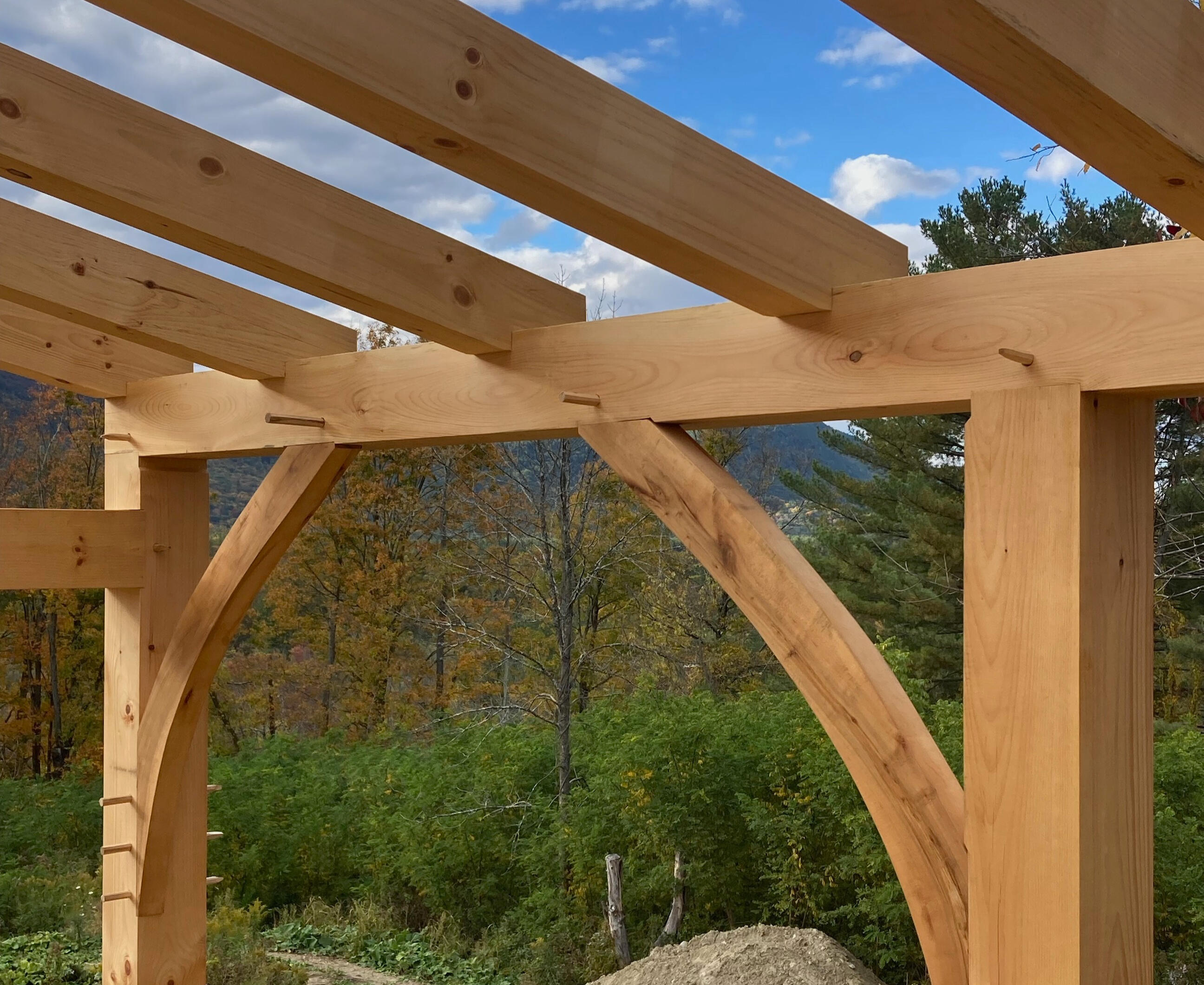Interior of custom timber frame home in the Berkshires with natural curved braces and rafters